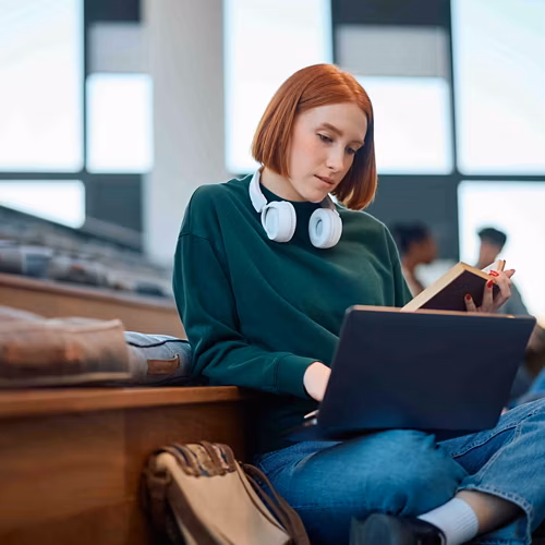 Student reading and typing in lecture hall
