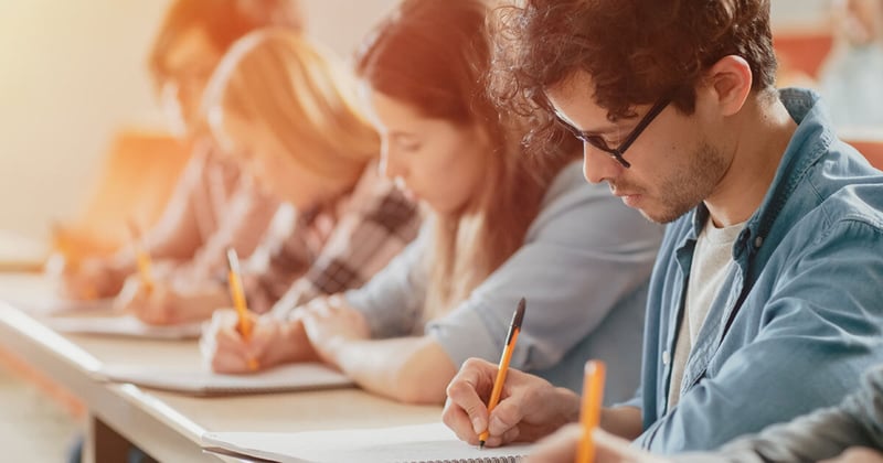 Students writing at a desk
