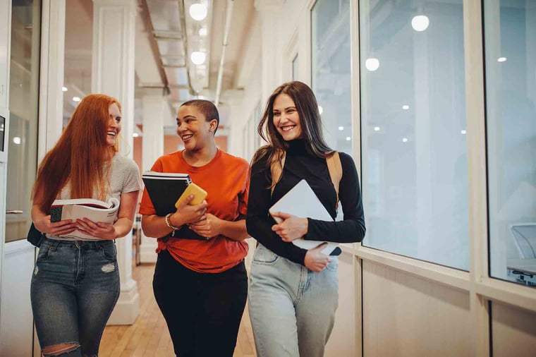Friends walking together down the hall holding school books