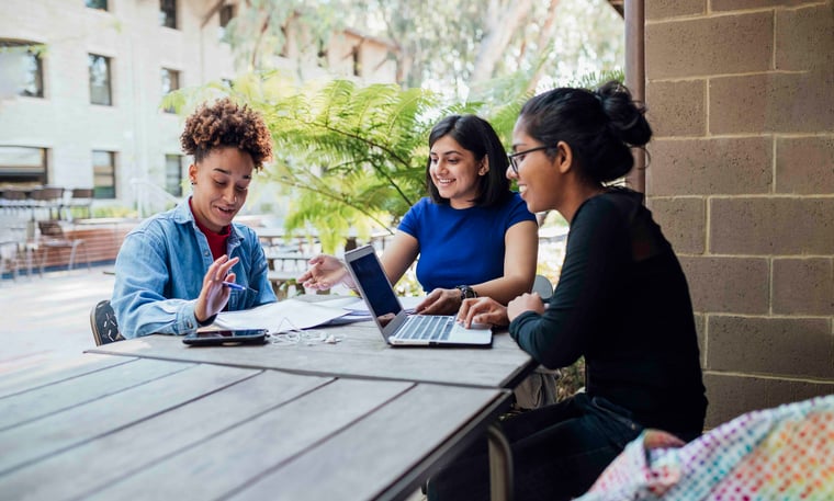 Three people sitting around a table working together