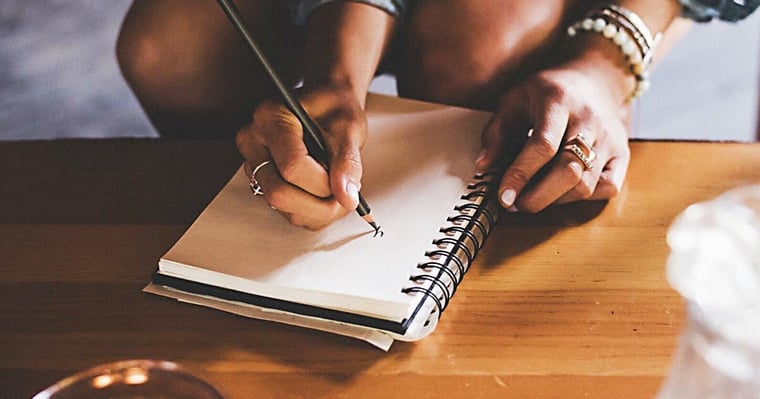 closeup on someone writing in a notebook