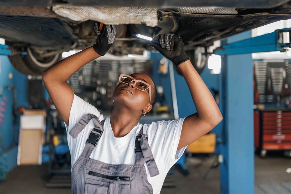 Person under a car doing mechanical work