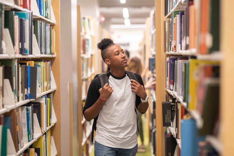 Person in library looking at rows of books