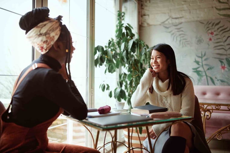 Two women sitting at a table chatting