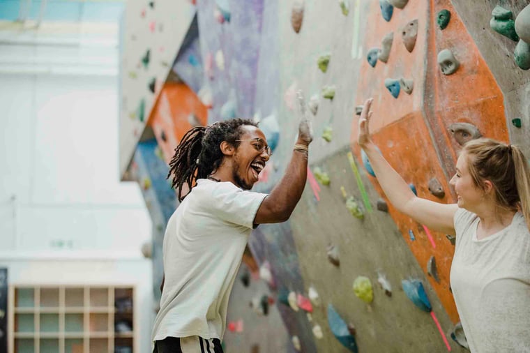 People high-fiving at rock climbing facility