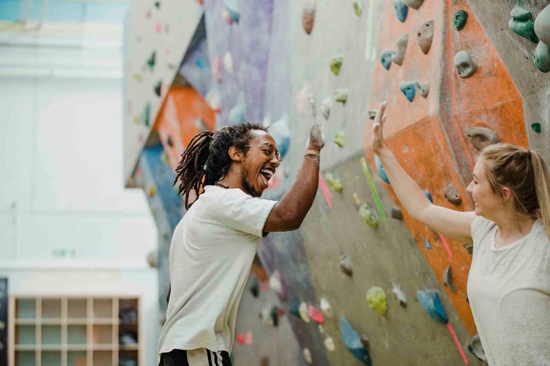 People high-fiving at rock climbing facility